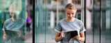 Girl in front of building on her tablet