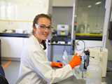 Female lab technician performing test in lab environment. Levasil CA enable reproducible and robust production of synthetic zeolites.