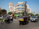 Cars and motors on the street in front of an authentic building