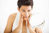 Young man touching his face after cleansing. Our multifunctional products enable formulators to create mild shampoos, two-in-one shampoo conditioners, mousse, bath and shower gels, body wash, facial wash, liquid hand soap, baby cleansers and shaving creams.