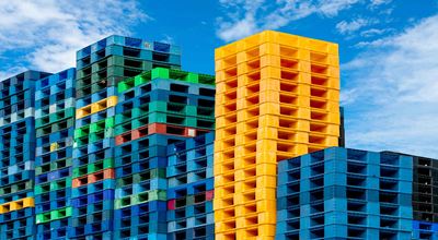 Colored crates stacked outside against a backdrop of a blue sky