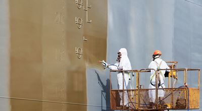 Men painting a large cargo ship