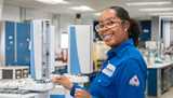 Nouryon employee wearing blue overalls and protective glasses at the lab