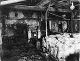 Two workers in aprons stand in an old industrial workshop in California.